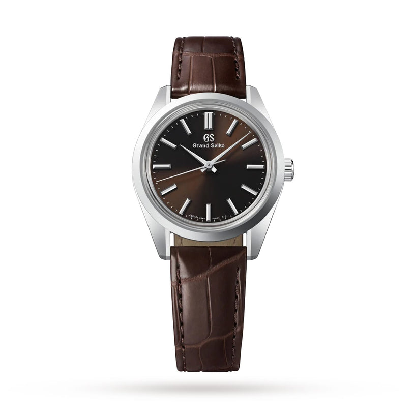 The Grand Seiko Manual Heritage dress watch, showcasing the iconic 44GS design with a silver case, brown sunburst dial, silver markers, and a brown leather strap, is displayed against a white background.