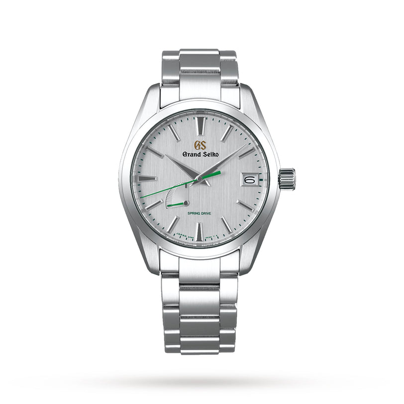 The Grand Seiko Spring Drive Heritage is a stainless steel wristwatch with Japanese craftsmanship, a silver dial, green second hand, Spring Drive movement, date at 3 oclock, and a metal link bracelet.