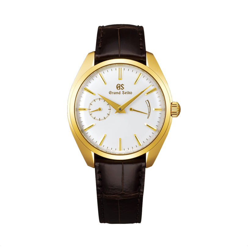 The Grand Seiko Manual Elegance features an 18K yellow gold case, white dial, brown leather strap, gold hour markers, a small seconds subdial at 9 o’clock, and is powered by the Caliber 9S63 movement.