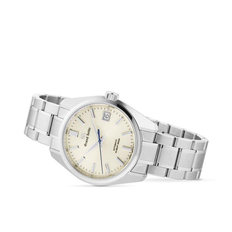 The Grand Seiko Hi-Beat Heritage wristwatch features an Ever-Brilliant Steel band, cream dial, silver hour markers, and a date window at 3 o’clock.
