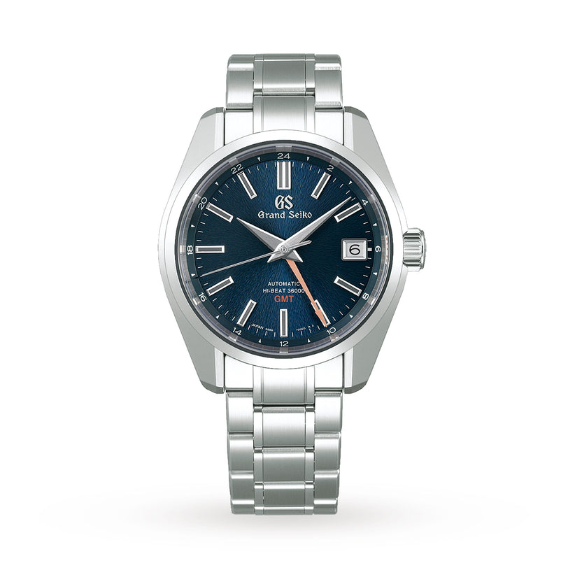The Grand Seiko Hi-Beat GMT Heritage watch features a blue dial, silver hour markers, date window at 3 o’clock, stainless steel case, and a silver bracelet.