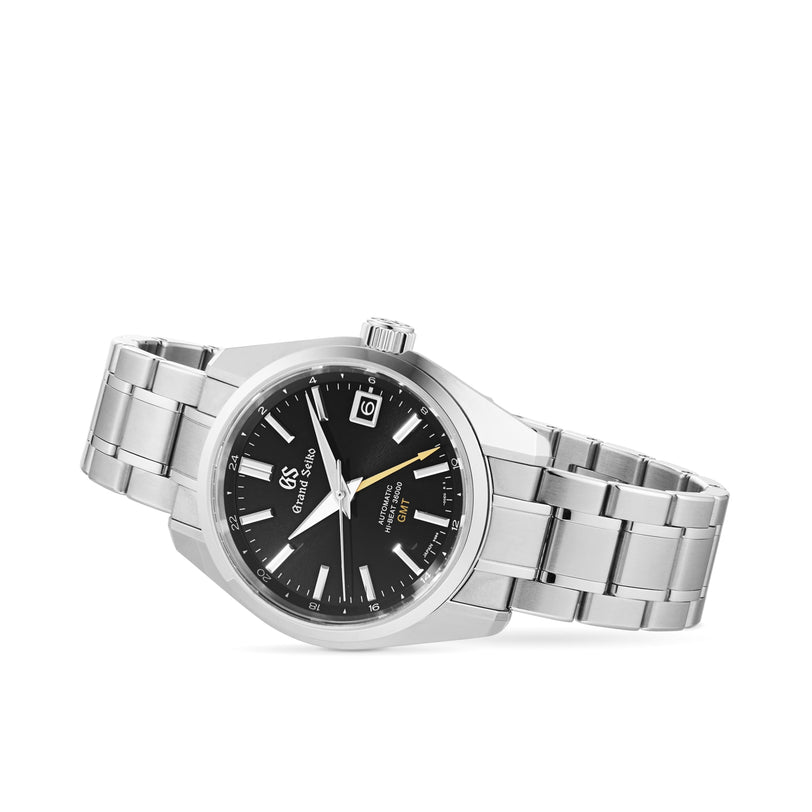 The Grand Seiko Hi-Beat GMT Heritage stainless steel watch features a black dial, date at 3 o’clock, silver hour markers, and the precise 9S86 automatic movement, displayed against a white background.