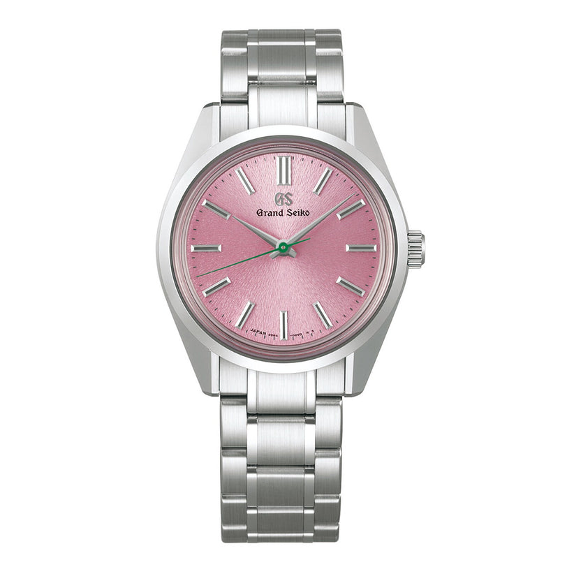 The Grand Seiko Manual Heritage is a stainless steel watch featuring a pink Sakura-inspired textured dial, silver hour markers and hands, and a metal link bracelet.