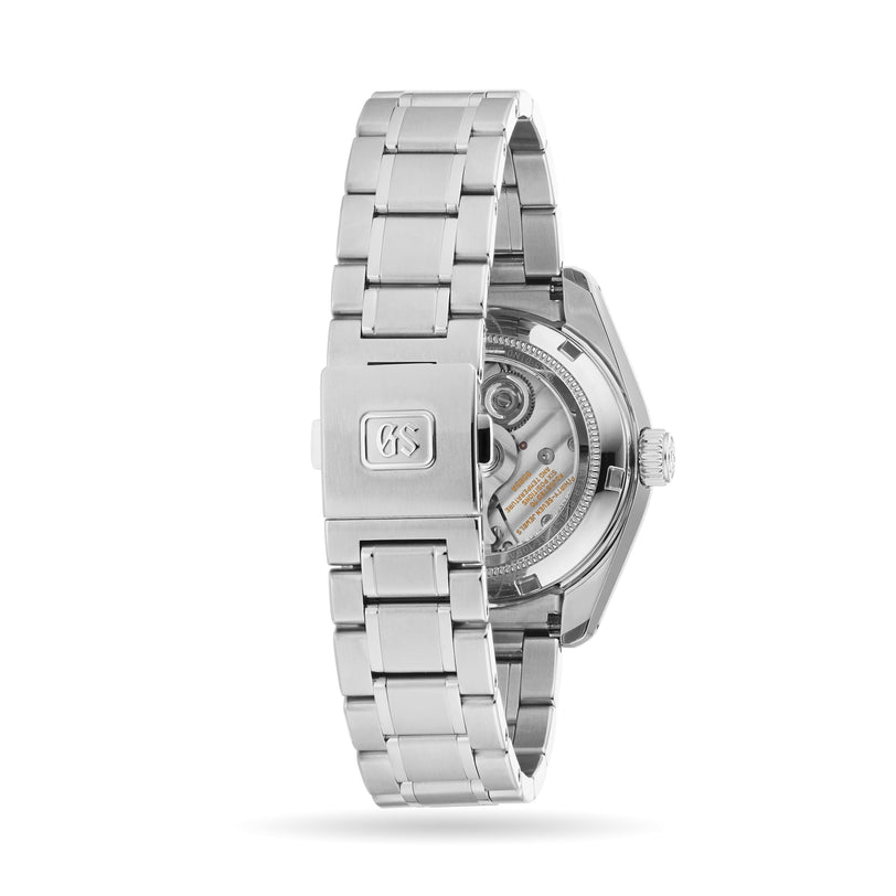 Grand Seikos Hi-Beat Heritage wristwatch, viewed from the back, reveals its stainless steel bracelet, clasp engraved with the Grand Seiko logo, and hi-beat movement visible through a transparent caseback.