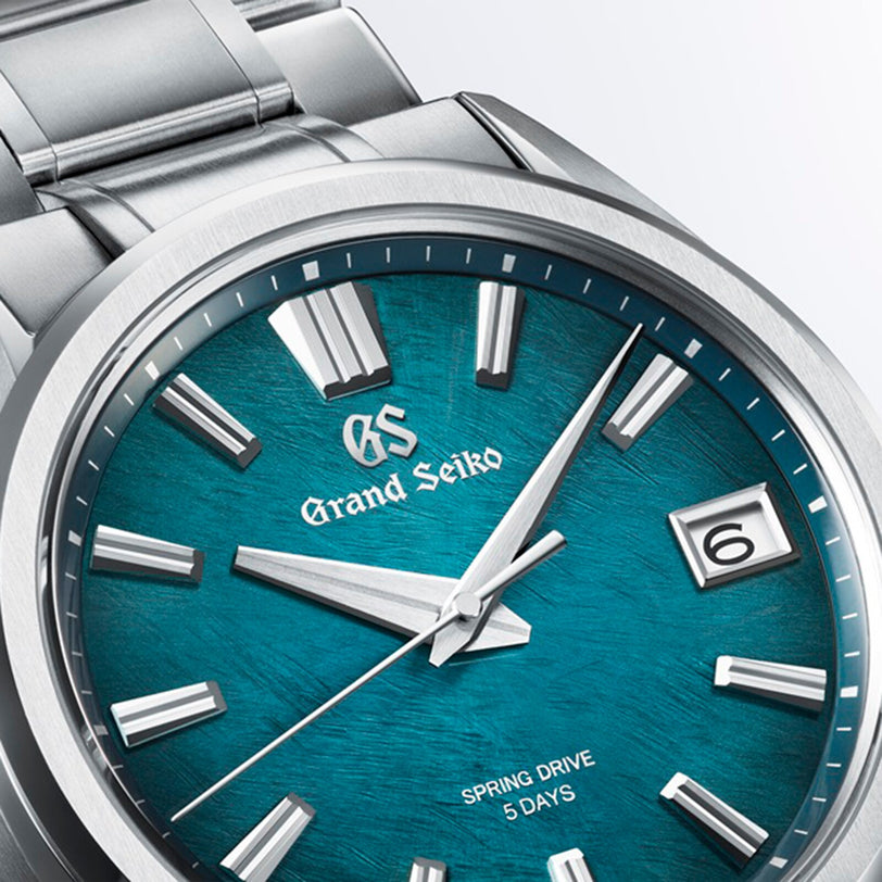 Close-up of the Grand Seiko Spring Drive 5 Days Evolution 9 watch, featuring a teal textured dial, silver markers, and a date display at 3 o’clock.