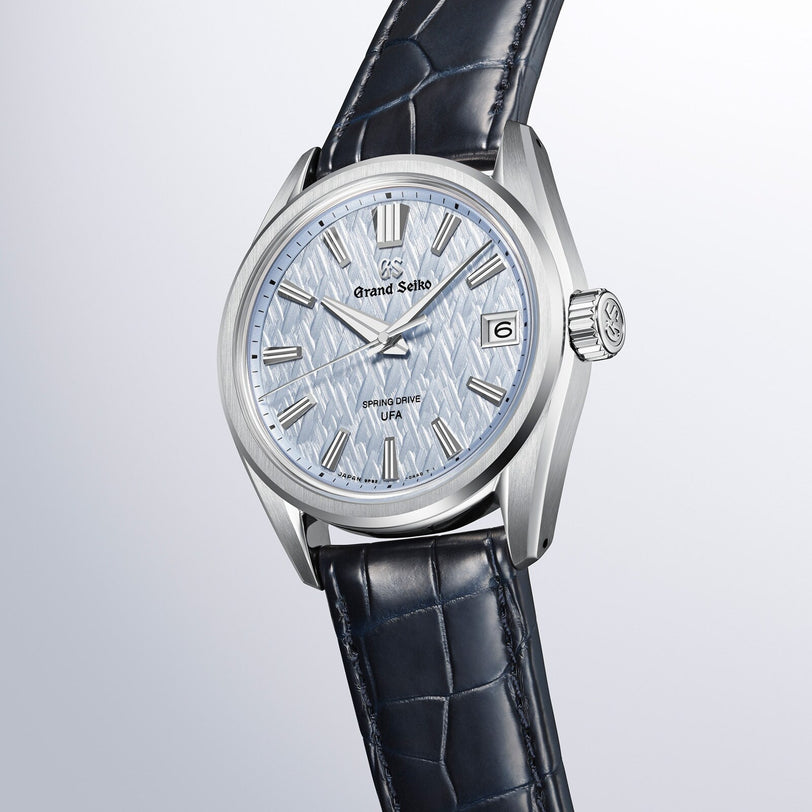 Grand Seiko Spring Drive U.F.A Evolution 9 wristwatch featuring a textured light blue dial and dark blue leather strap, shown on a white background.