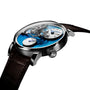 The MB&F Legacy Machine LM101 Steel Blue is a luxury wristwatch featuring a blue face, brown leather strap, and an exposed mechanical movement.