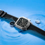 The Gerald Charles Maestro 3.0 Chronograph, a stainless steel watch with a black strap, is showcased on a blue surface with water ripples and splashes, emphasizing its water-resistant design.