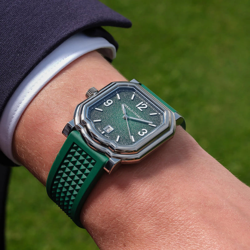 A Gerald Charles Maestro GC Sport wristwatch with a green and silver design and textured strap is worn on a wrist outdoors on a sunny day.