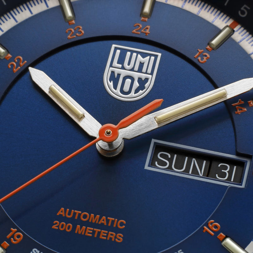 Close-up of the Luminox Atacama Field Automatic Stainless Steel Urban Adventure watch face displaying time, day, date, and water resistance details.