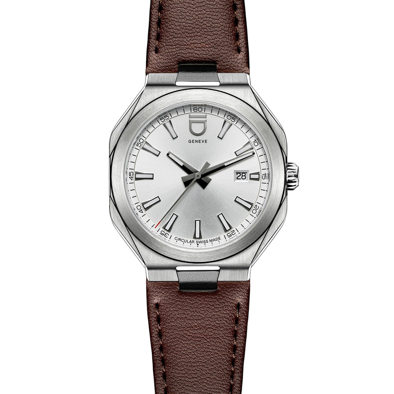 The Circular 1 Original - Silver by ID Geneve is a silver analog wristwatch featuring a brown leather strap and a date display on the right side of the dial.