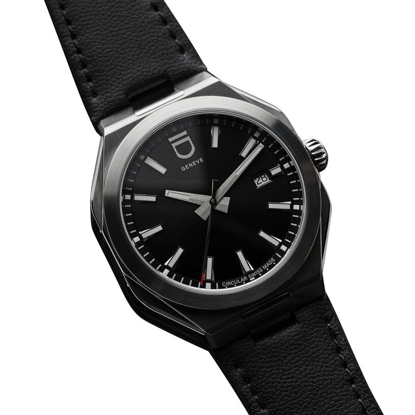 The Circular 1 - Black by ID Geneve is a black wristwatch with a round face, silver details, a black leather strap, and date display.