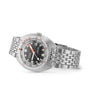 The DOXA Sub 300 Sharkhunter, a stainless steel divers watch with a black dial, orange and white markers, unidirectional bezel, date display, and metal link bracelet is shown angled on a white background.