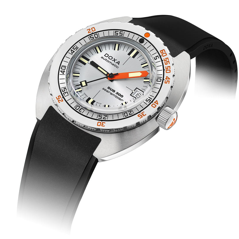 The DOXA Sub 300 Searambler is a silver divers watch with a white dial, orange minute hand, black rubber strap, and a unidirectional bezel accented with bold orange markings.