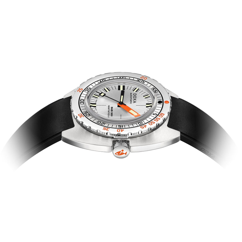 A close-up side view of the DOXA Sub 300 Searambler divers watch shows its silver case, black strap with orange accents, and a crown featuring an orange logo, emphasizing the unidirectional bezel.