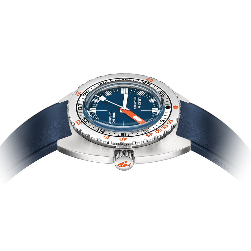 The DOXA Sub 300 Caribbean diver’s watch, featuring a blue dial and strap, silver case, orange accents, and unidirectional bezel, is shown from a side angle against a white background.