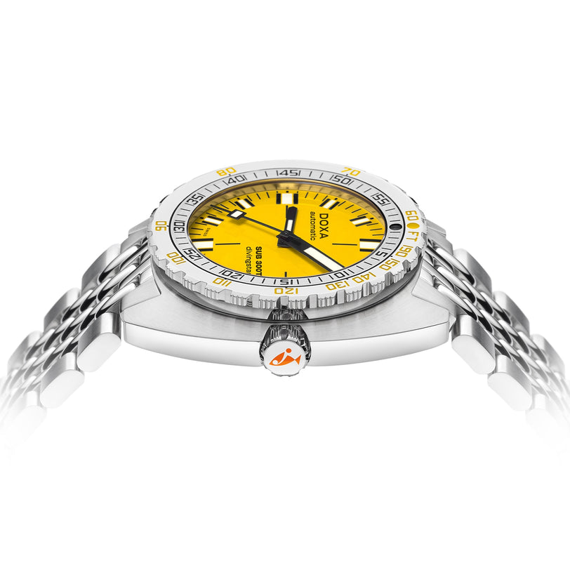 A close-up side view of the DOXA Sub 300T Divingstar displays its silver case, yellow dial with black markers, helium release valve, and stainless steel bracelet against a white background.