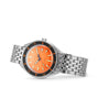 The DOXA Sub 200 Professional divers watch, made of 316L stainless steel, showcases an orange dial, black unidirectional bezel, silver hour markers, a date window at 3 o’clock, and a metal link bracelet set against a white background.