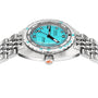 The DOXA Sub 300 Aquamarine is a stainless steel diver’s watch with a turquoise dial, black markers, and metal bracelet, shown from a side angle. The crown displays an orange fish logo.