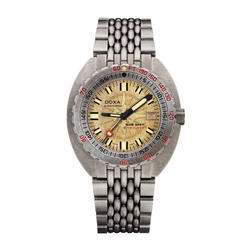 The DOXA Sub 300T Clive Cussler is a vintage-inspired dive watch featuring a worn yellow dial, stainless steel case, Swiss automatic movement, date display, metal bracelet, red and black bezel markings, and 1200m water resistance.