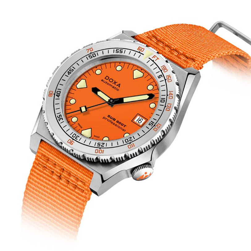 The DOXA Sub 600T Professional diver’s watch features an orange dial, date display, stainless steel case, and orange fabric strap, shown against a white background.