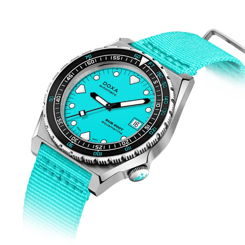 The DOXA Sub 600T Aquamarine divers watch features a turquoise dial, matching nylon strap, black rotating bezel, and silver 316L stainless steel case, displayed against a white background.