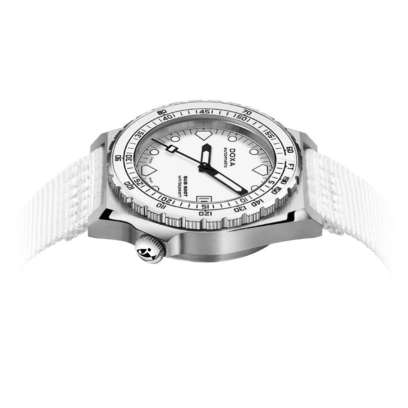 The DOXA Sub 600T Whitepearl is a silver and white diver’s watch with a rotating bezel, bold black markers, a white fabric strap, and a prominent crown on the left side.