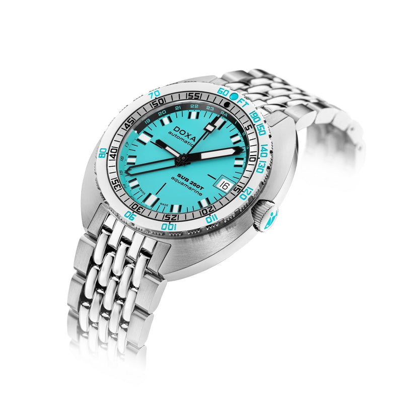 The DOXA SUB 250T GMT Aquamarine is a dive watch featuring an aquamarine dial, silver indices, date at 3 o’clock, a stainless steel case, and a matching stainless steel bracelet.