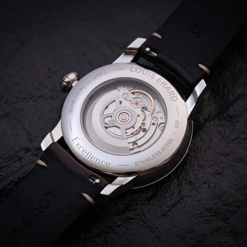 A close-up of the Louis Erard Petite Seconde Terracotta 42’s back displays its exposed mechanical movement and black leather strap.