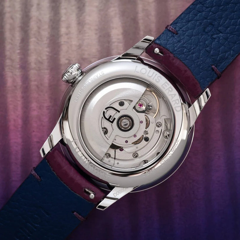 Close-up of the Louis Erard Petite Seconde Violette’s open caseback, revealing its intricate movement and blue leather strap.