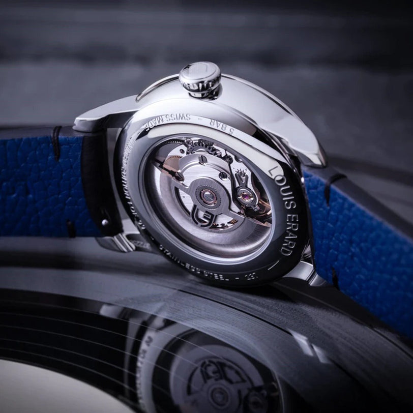 Close-up of the Louis Erard Guilloché Main II showcasing its exposed mechanical movement and blue leather strap.