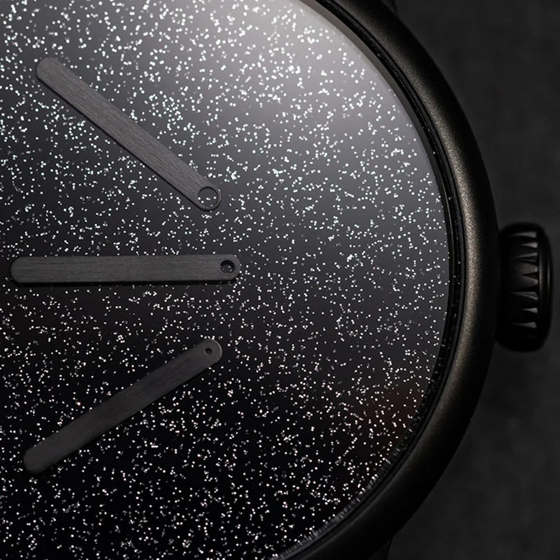 Close-up of the Le Régulateur Louis Erard x Olivier Mosset watch by Louis Erard, featuring a minimalist face with a starry night sky design and three simple, dark hands.