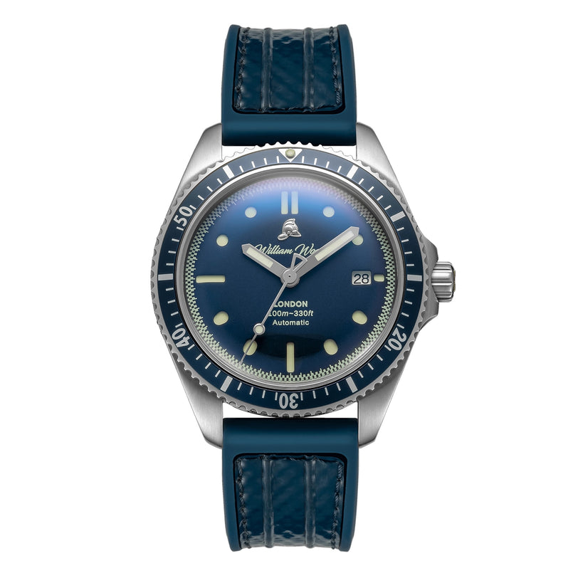 The Valiant Collection - The Blue Watch by William Wood features a silver case, blue dial and bezel, blue stitched leather strap, and a date display at 3 oclock.