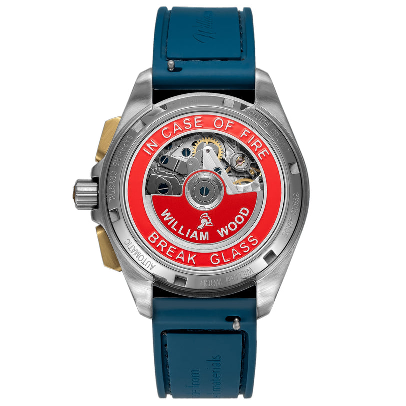 The Triumph Collection - Oxygen Edition by William Wood features a watch back with a red fire alarm design reading IN CASE OF FIRE BREAK GLASS and comes with a blue strap.
