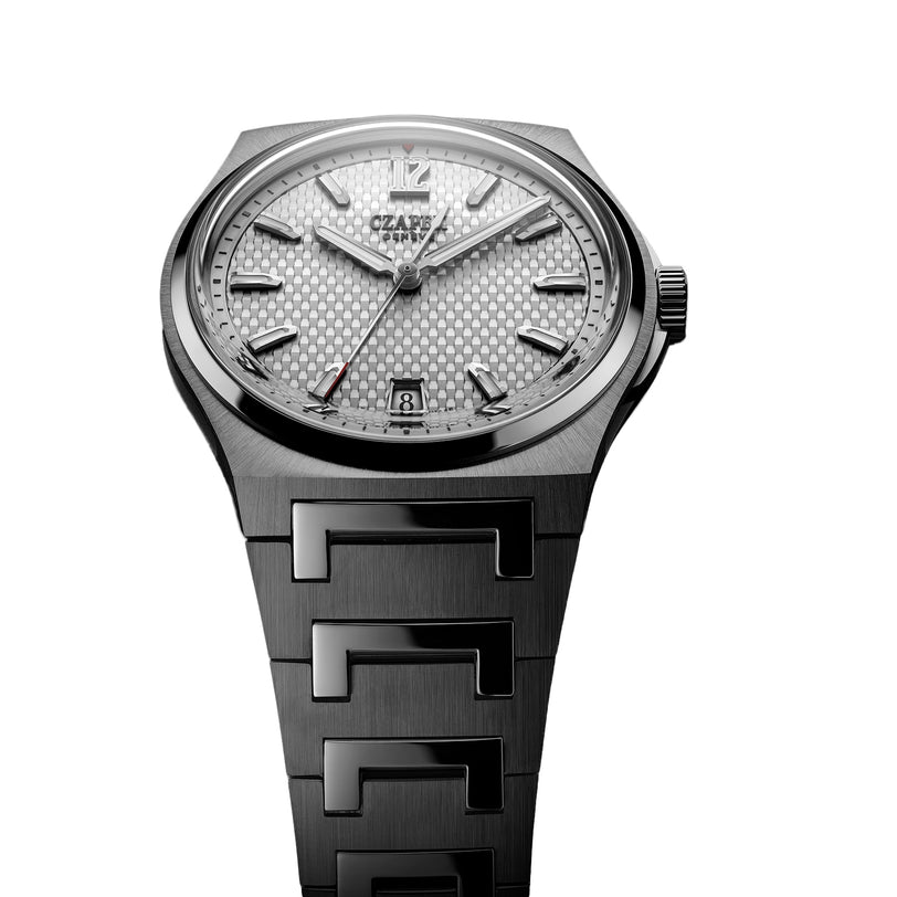 The Czapek Antarctique Passage de Drake Ice White is a silver luxury wristwatch featuring a patterned dial, date window, and metal link bracelet, shown on a white background.