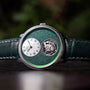 The Arnold & Son Ultrathin Tourbillon Platinum is a luxury watch featuring a green textured dial, white subdial, exposed tourbillon, and green leather strap.