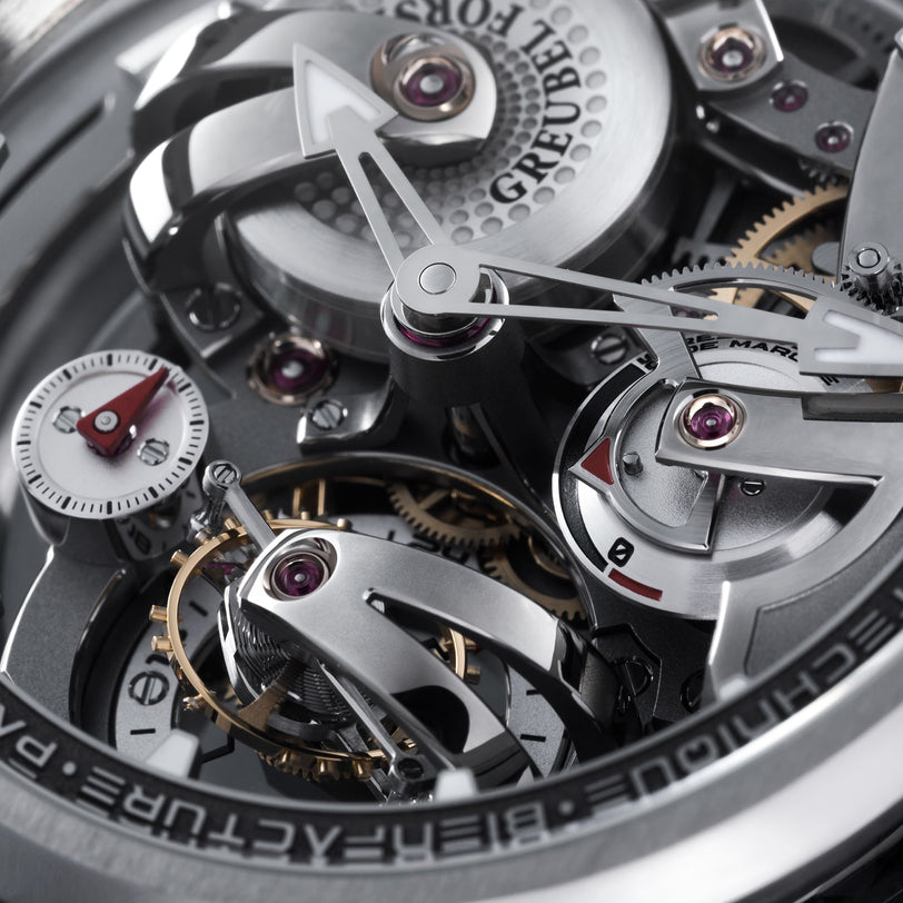 Close-up of the Greubel Forsey Tourbillon 24 Secondes Architecture, highlighting its intricate gears, screws, detailed components, visible brand engraving, and the elegant complexity of its tourbillon for a true architectural experience.