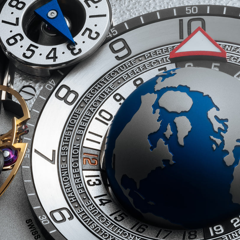 Close-up of the Greubel Forsey GMT Balancier Convexe watch face, showcasing a blue globe and intricately engraved numbers and words.