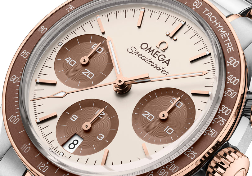 Speedmaster 38mm chronograph with cream dial, rose gold and stainless steel two-tone case, and brown tachymeter bezel.