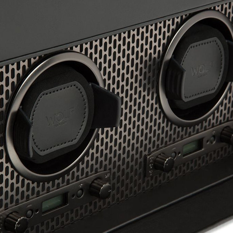 Close-up of the WOLF Axis Double Watch Winder With Storage featuring black holders and digital control knobs on a patterned metal surface.