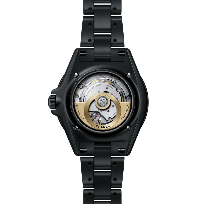 Black Chanel watch with open face design on a white background
