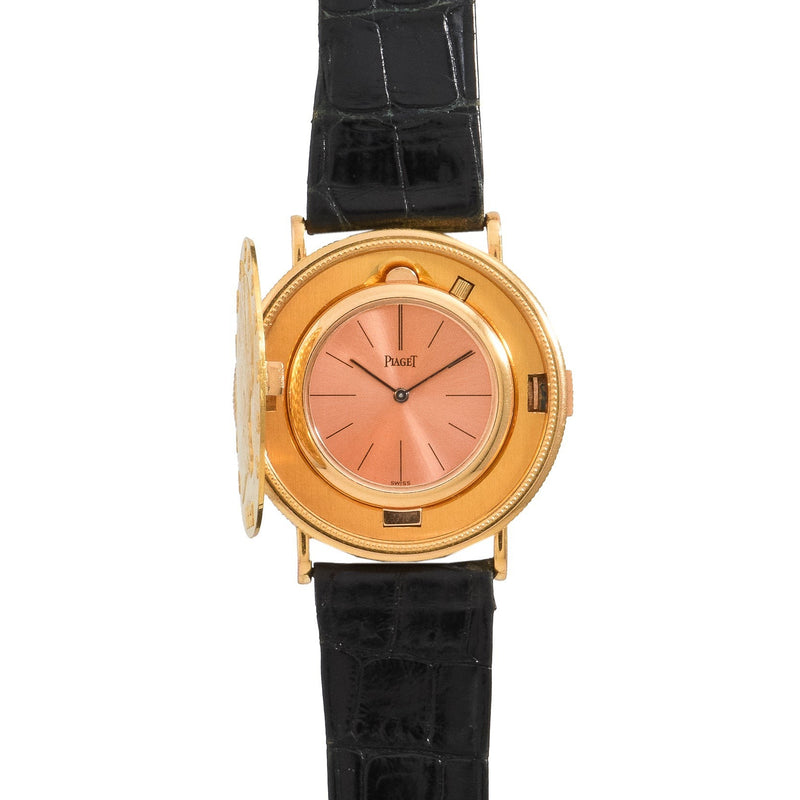 The Piaget 1877 Twenty Dollar Coin Watch features a gold case, pink dial, black leather strap, and an open decorative cover.