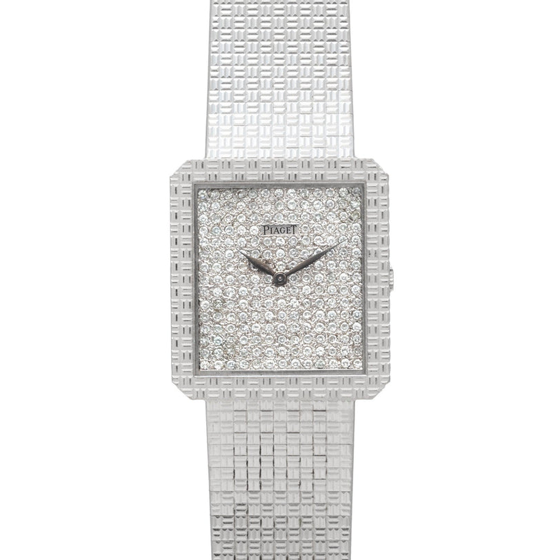 The Brick Diamond Dress Watch by Piaget features a square face, diamond-encrusted dial, and a textured silver metal band.