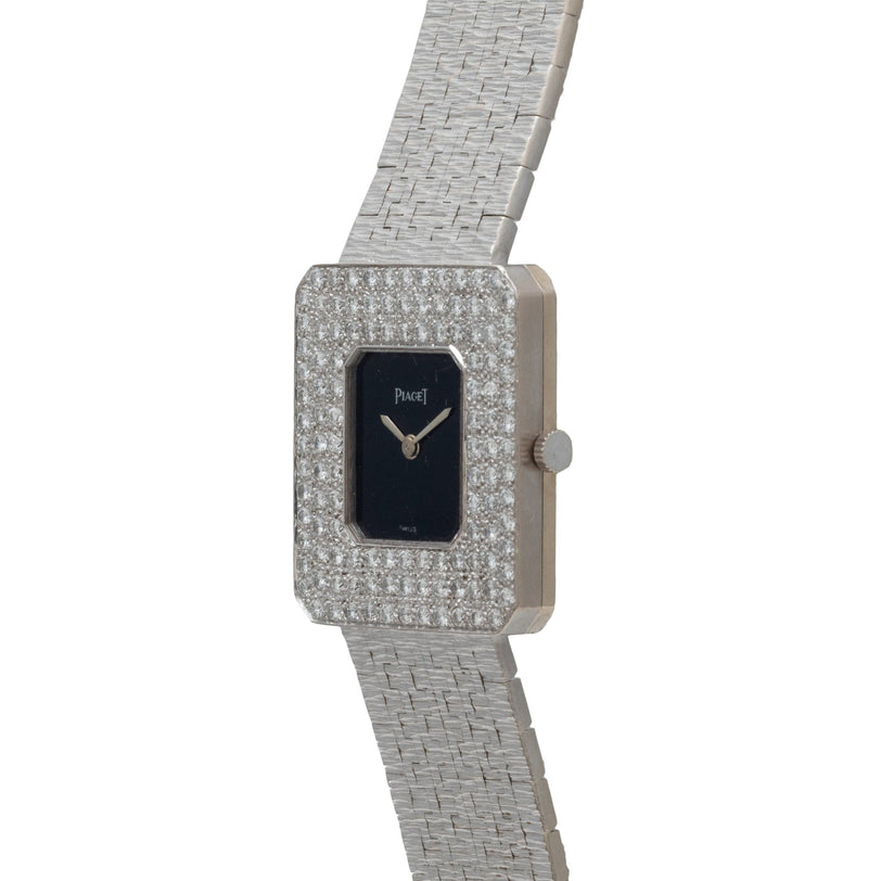 The Piaget Onyx Diamond Dress Watch features a diamond-encrusted rectangular face and a sleek silver metal band.