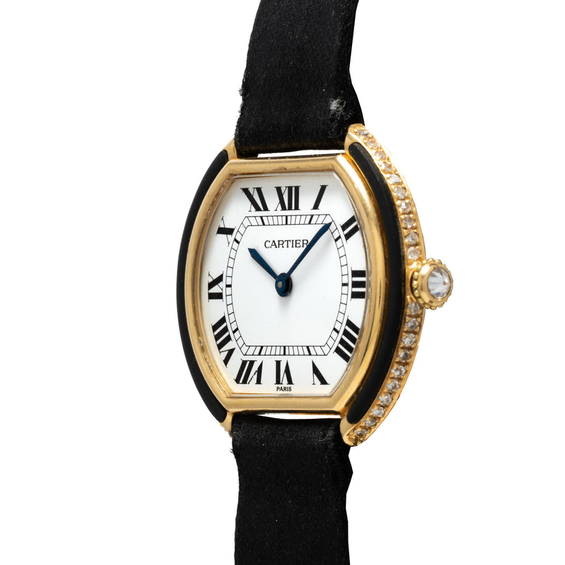 Cartier Ellipse Gondole watch with gold tonneau case, white dial, Roman numerals, black leather strap, and diamond bezel.