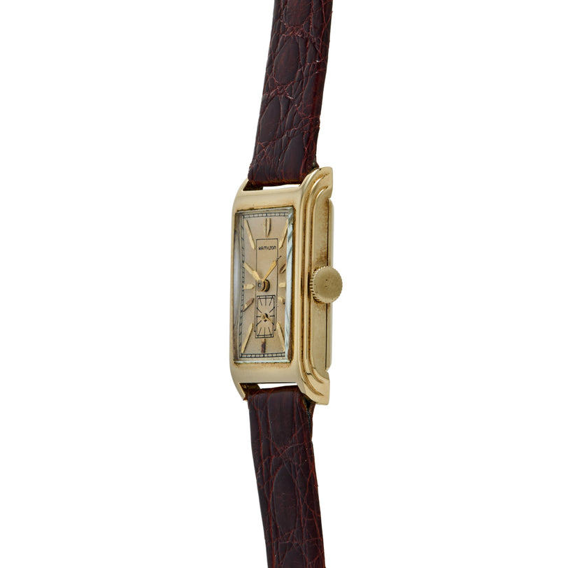 Gold-tone rectangular watch with cream dial, dual subdials, and dark brown croc-embossed leather strap.