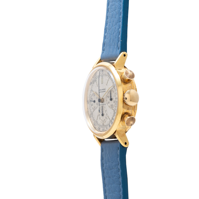 Movado M95 chronograph watch with gold-tone case, silver dial, and blue leather strap.