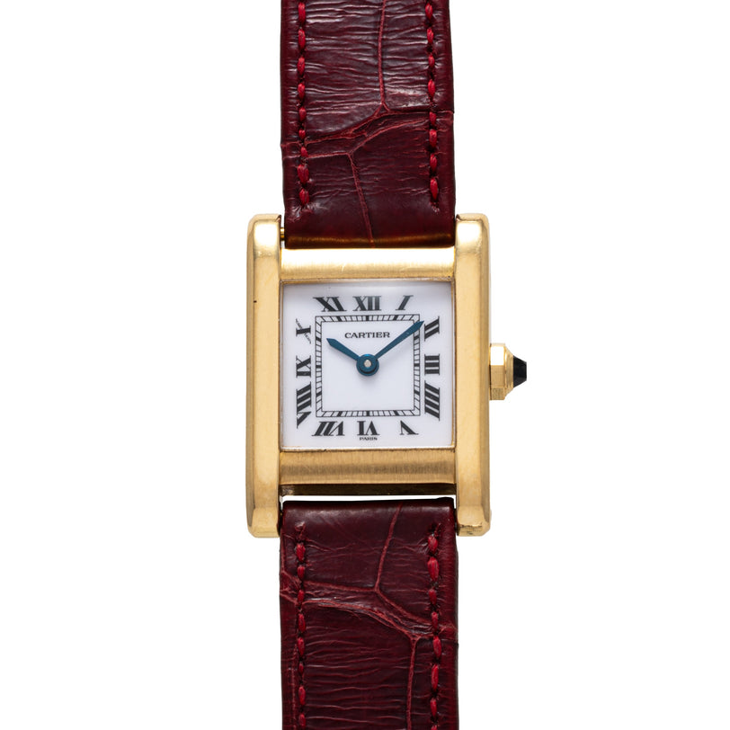 Gold-tone rectangular watch with white dial, Roman numerals, and burgundy alligator leather strap with red stitching.