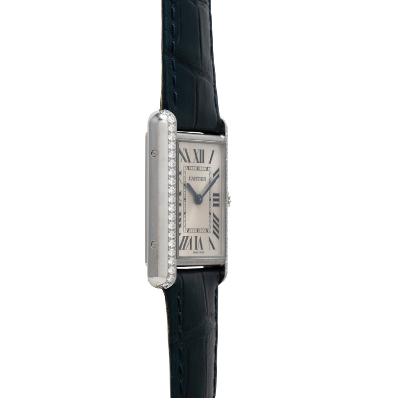 Cartier Tank Must watch with rectangular silver dial, Roman numerals, diamond-set bezel, and black leather strap.