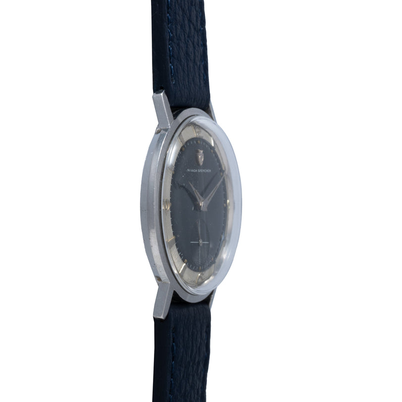 Vintage Nivada Grenchen watch with dark dial, sub-seconds subdial, and black fabric strap.